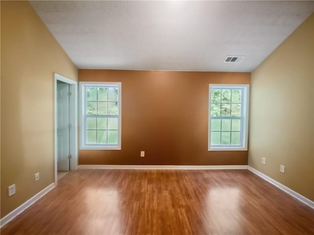 unfurnished room with hardwood / wood-style flooring