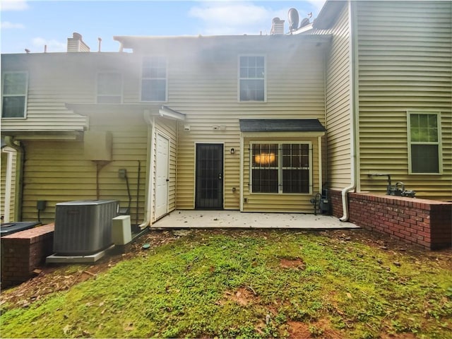 back of property with central AC unit, a yard, and a patio