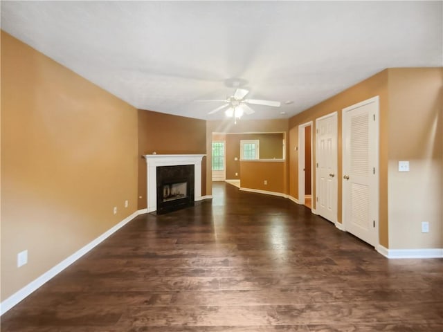 unfurnished living room featuring ceiling fan and dark wood-type flooring