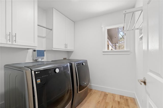 clothes washing area featuring cabinets, light hardwood / wood-style flooring, and independent washer and dryer