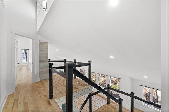 hallway featuring a skylight, a wealth of natural light, and light hardwood / wood-style flooring