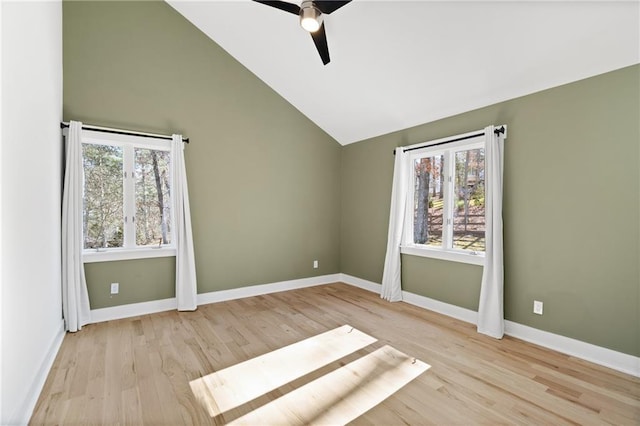 spare room featuring ceiling fan, a wealth of natural light, high vaulted ceiling, and light wood-type flooring