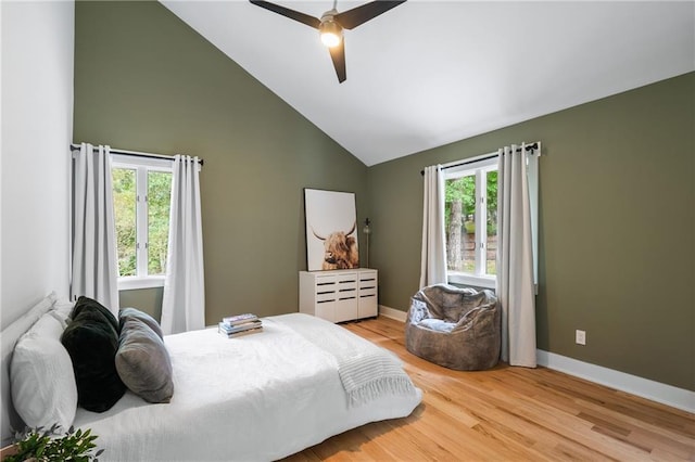 bedroom with light wood-type flooring, ceiling fan, and high vaulted ceiling