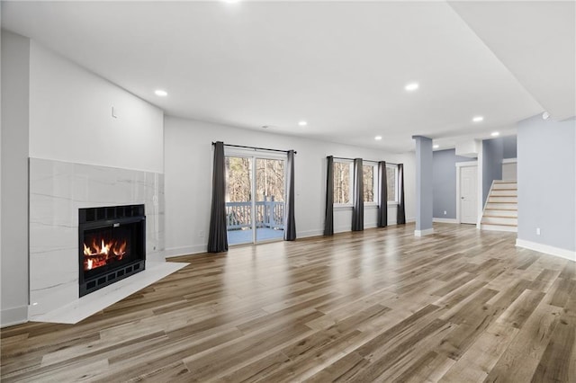 unfurnished living room with light hardwood / wood-style floors and a tiled fireplace