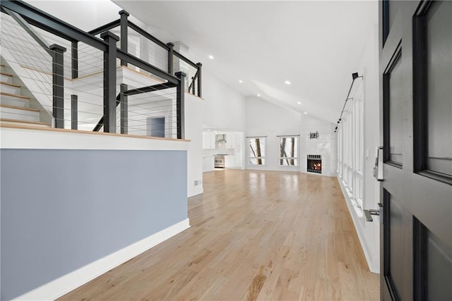 foyer featuring high vaulted ceiling and light hardwood / wood-style flooring