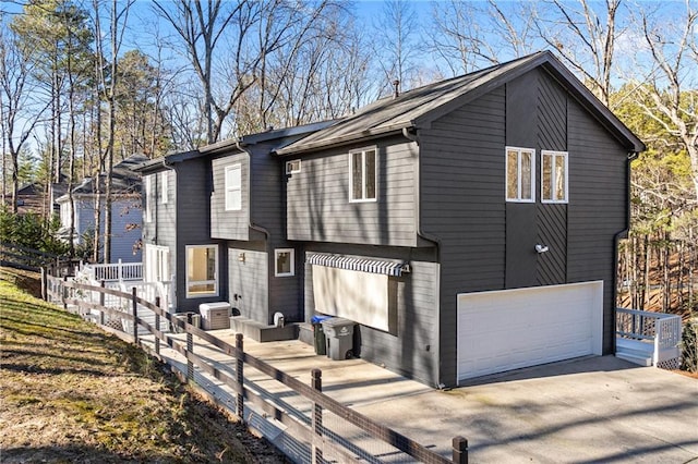 view of front of property featuring central AC unit and a garage