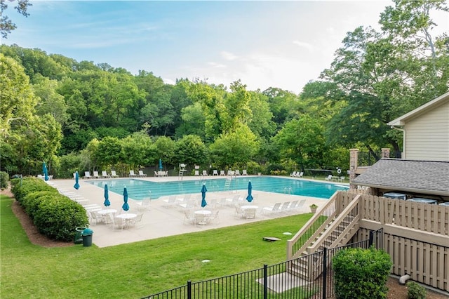 view of pool with a patio area and a lawn