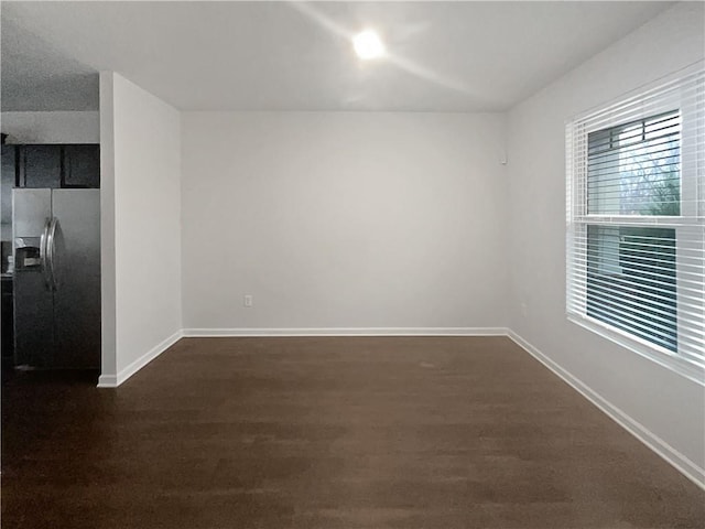 empty room with dark wood finished floors and baseboards