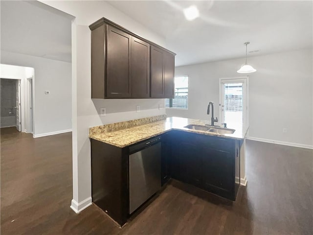 kitchen with dark wood-style floors, stainless steel dishwasher, a sink, dark brown cabinets, and a peninsula