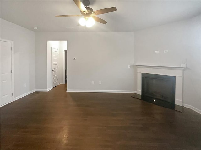 unfurnished living room featuring ceiling fan, baseboards, wood finished floors, and a glass covered fireplace