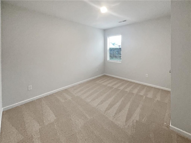 unfurnished room with carpet flooring, visible vents, and baseboards