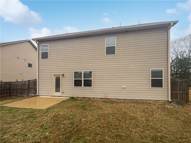 back of property with a yard, a patio area, and fence