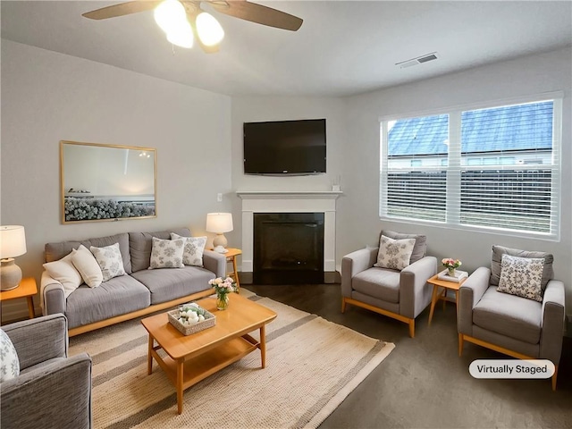 living room featuring ceiling fan, a fireplace with flush hearth, and visible vents