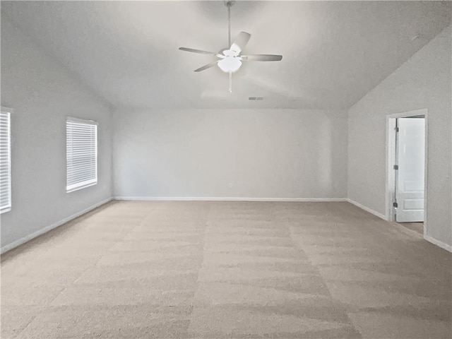 unfurnished room featuring vaulted ceiling, carpet flooring, a ceiling fan, and baseboards