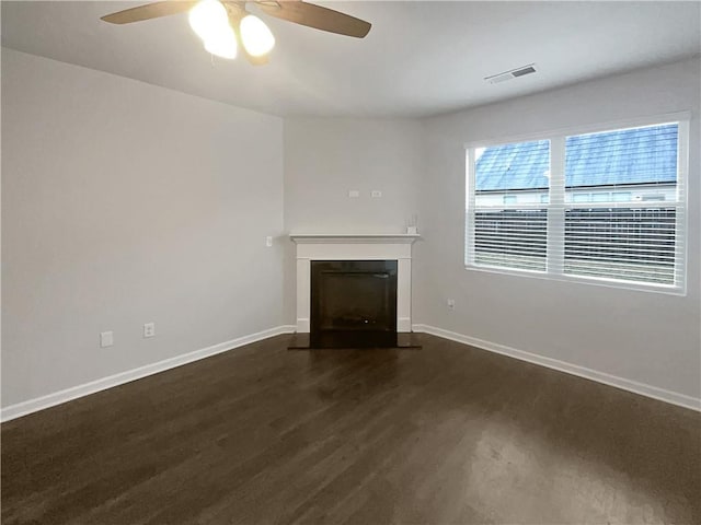 unfurnished living room featuring baseboards, a fireplace with flush hearth, visible vents, and wood finished floors