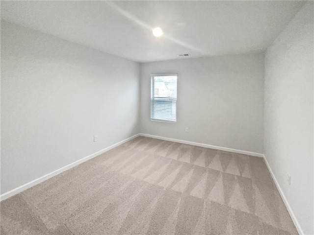 unfurnished room with light colored carpet, visible vents, and baseboards