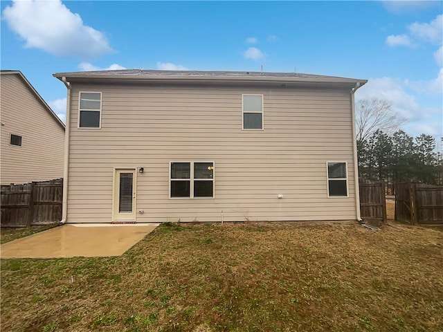 rear view of house with a lawn, a patio area, and fence