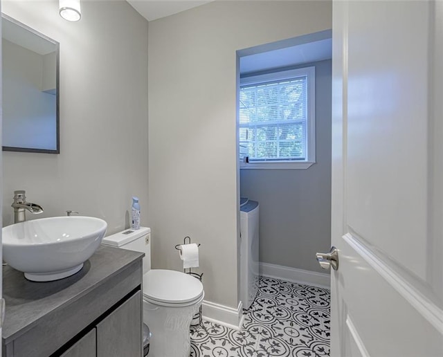 bathroom with tile patterned floors, vanity, toilet, and washing machine and clothes dryer