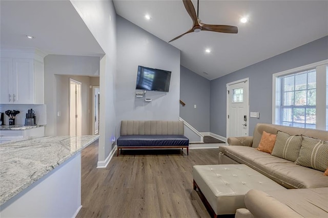 living room featuring light wood-type flooring, ceiling fan, and lofted ceiling