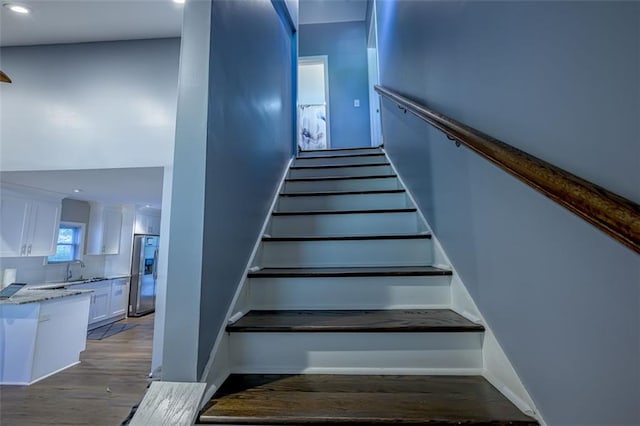 staircase featuring sink and hardwood / wood-style floors