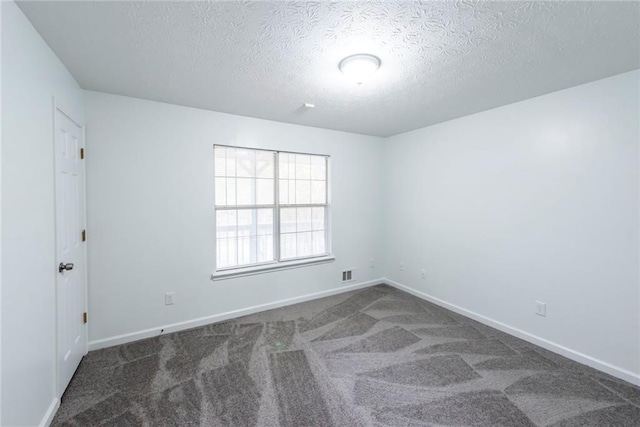 carpeted spare room featuring a textured ceiling