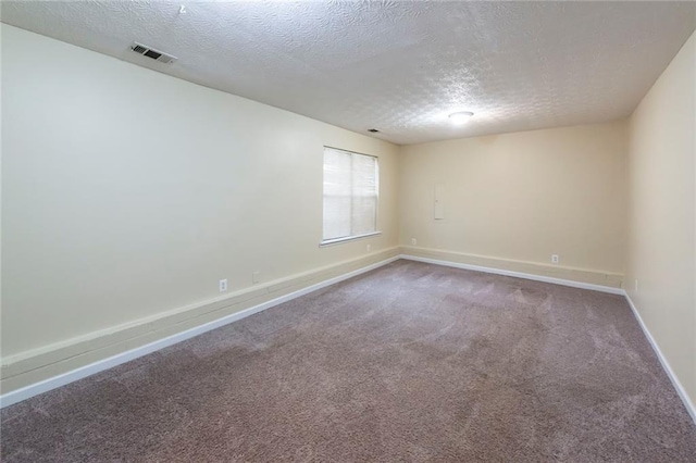 carpeted empty room with a textured ceiling