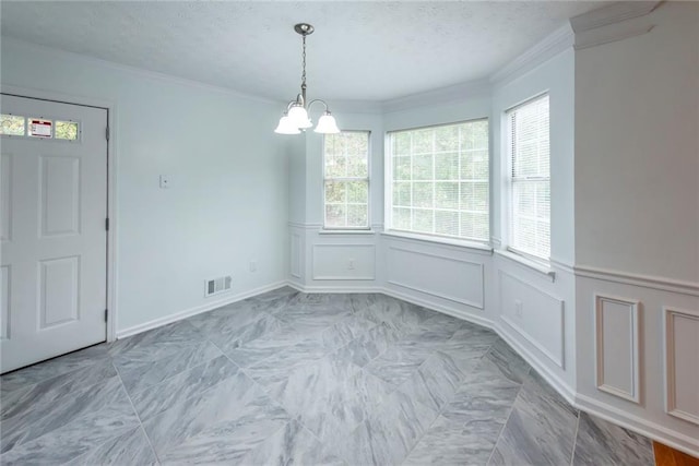 unfurnished dining area with a notable chandelier and crown molding