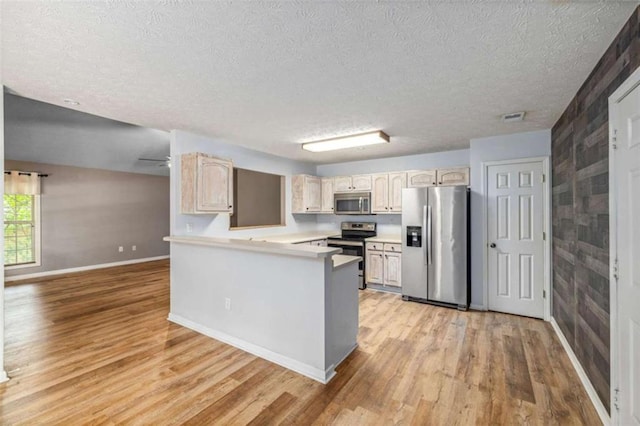 5375 Mountain View Pkwy, Lula, GA 30554 - kitchen with stainless steel appliances, light wood-style flooring, a textured ceiling, light countertops, and a peninsula