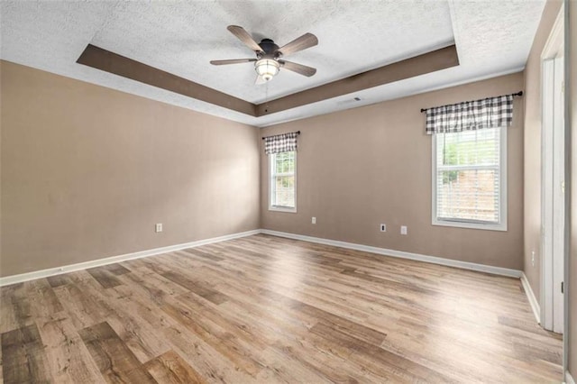 5375 Mountain View Pkwy, Lula, GA 30554 - unfurnished room with a textured ceiling, a tray ceiling, light wood-type flooring, and a ceiling fan