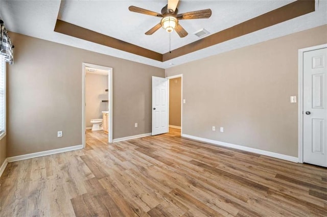 5375 Mountain View Pkwy, Lula, GA 30554 - unfurnished bedroom with a raised ceiling, wood finished floors, connected bathroom, and a ceiling fan