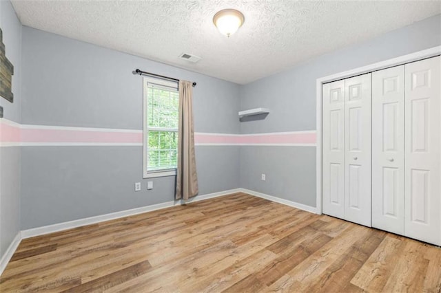 5375 Mountain View Pkwy, Lula, GA 30554 - unfurnished bedroom with wood finished floors, a textured ceiling, and a closet