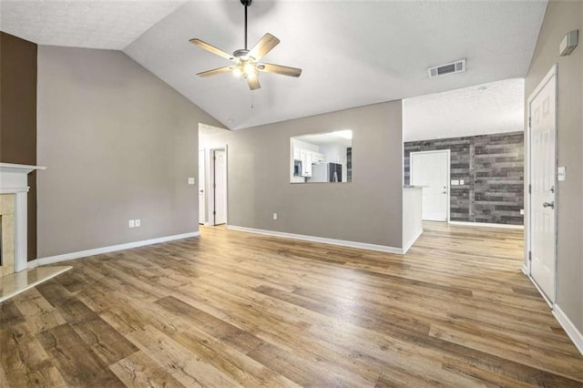 5375 Mountain View Pkwy, Lula, GA 30554 - unfurnished living room featuring ceiling fan, a fireplace, wood finished floors, lofted ceiling, and a textured ceiling