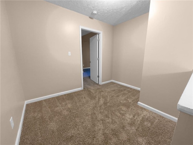 carpeted spare room with a textured ceiling