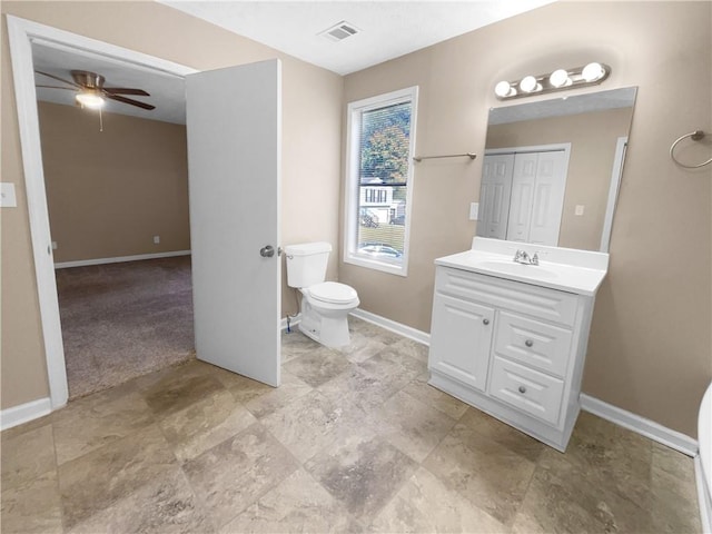 bathroom featuring toilet, vanity, and ceiling fan