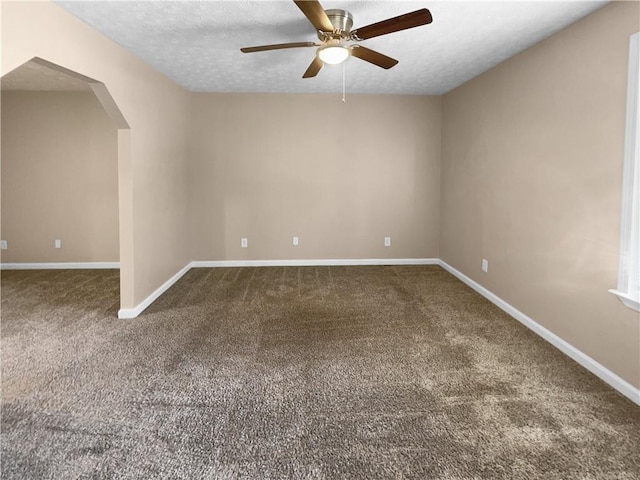 spare room with dark carpet, a textured ceiling, and ceiling fan