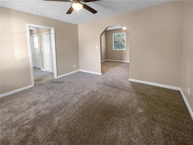 empty room featuring ceiling fan, carpet, and a textured ceiling