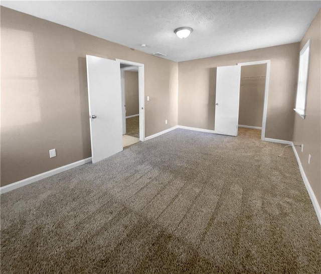 carpeted spare room featuring a textured ceiling