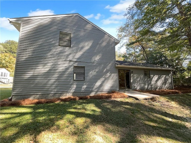 back of property featuring a patio and a lawn