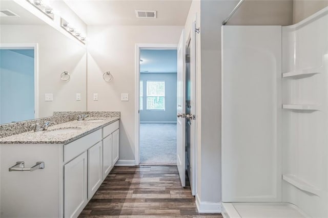 bathroom featuring large vanity, wood-type flooring, and double sink