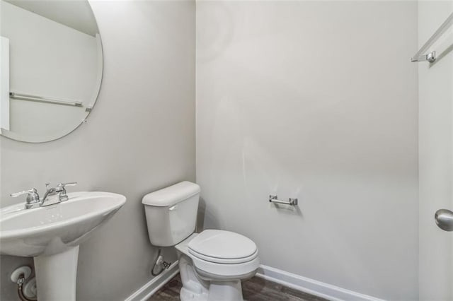 bathroom featuring wood-type flooring and toilet