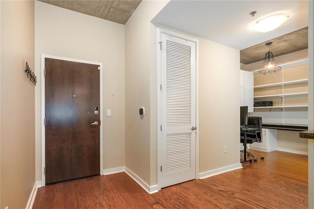 hallway featuring baseboards and wood finished floors