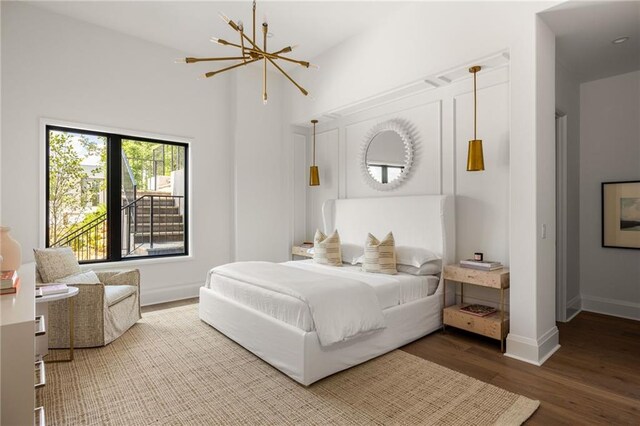 bedroom with hardwood / wood-style flooring and a chandelier