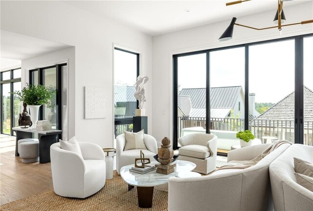 living room with a chandelier, light hardwood / wood-style floors, and a premium fireplace