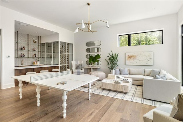 recreation room with light hardwood / wood-style floors and a chandelier