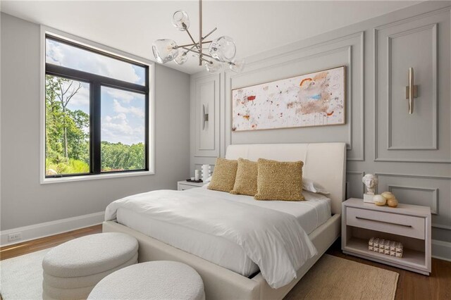 bedroom featuring hardwood / wood-style floors, a notable chandelier, and sink