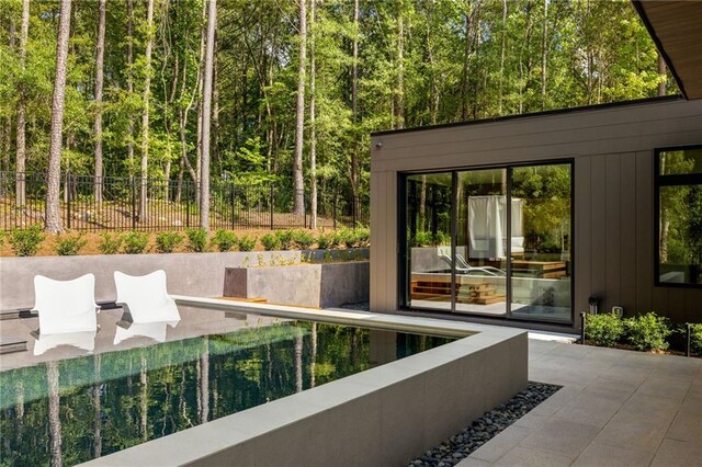 view of swimming pool featuring grilling area, a patio area, and exterior fireplace