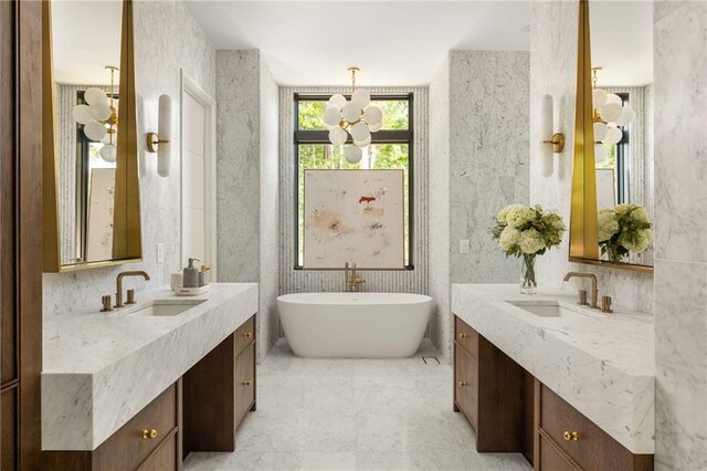 bathroom with vanity, a tub to relax in, and an inviting chandelier