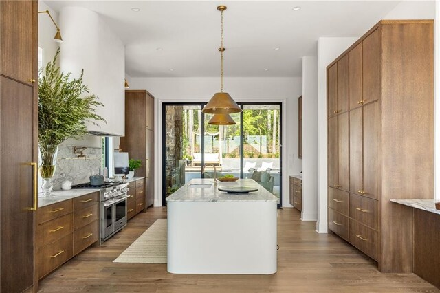 kitchen with sink, light wood-type flooring, kitchen peninsula, and backsplash