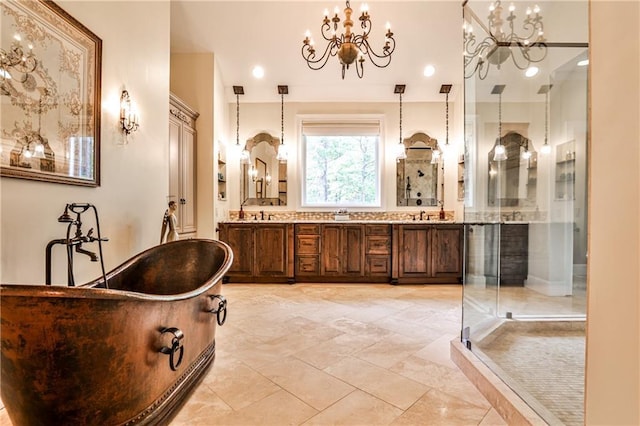 bathroom featuring double vanity, a notable chandelier, a freestanding bath, and a stall shower