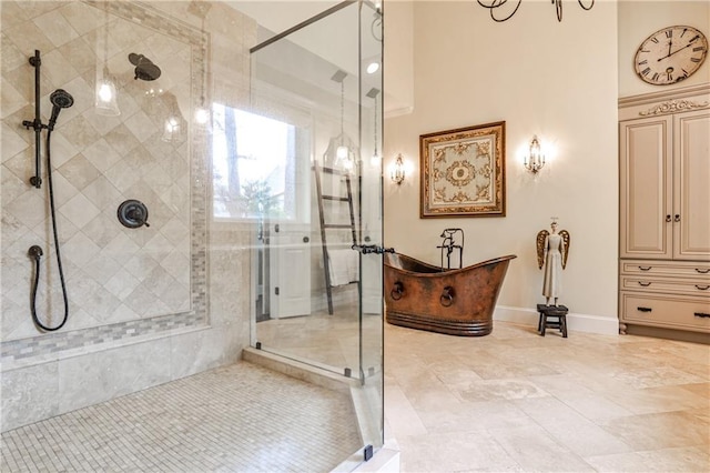 bathroom with a freestanding bath, baseboards, and a stall shower